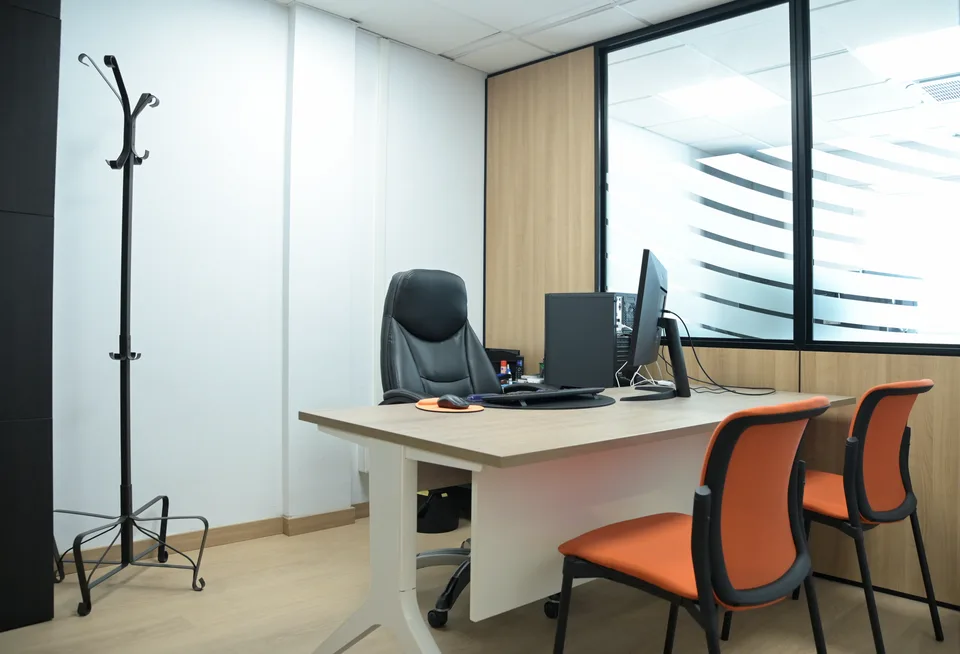 Despacho con mesa de trabajo y dos sillas para atención presencial.
