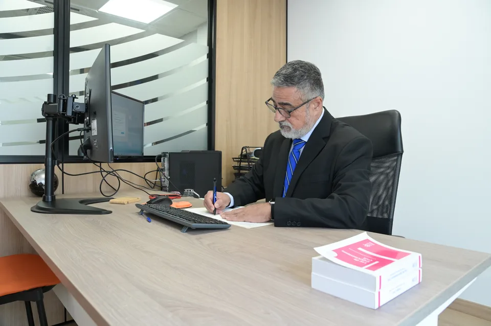 Rosendo Padrón tomando notas en su mesa de trabajo.